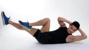 a man in a tank top performing lying bicycle crunches on a white background