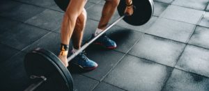 a person preparing to deadlift a loaded barbell using a wide grip